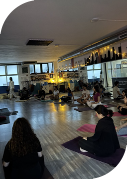 Gruppo di allievi seduti in meditazione durante una lezione di Kundalini Yoga, concentrati sul risveglio dell'energia interiore
